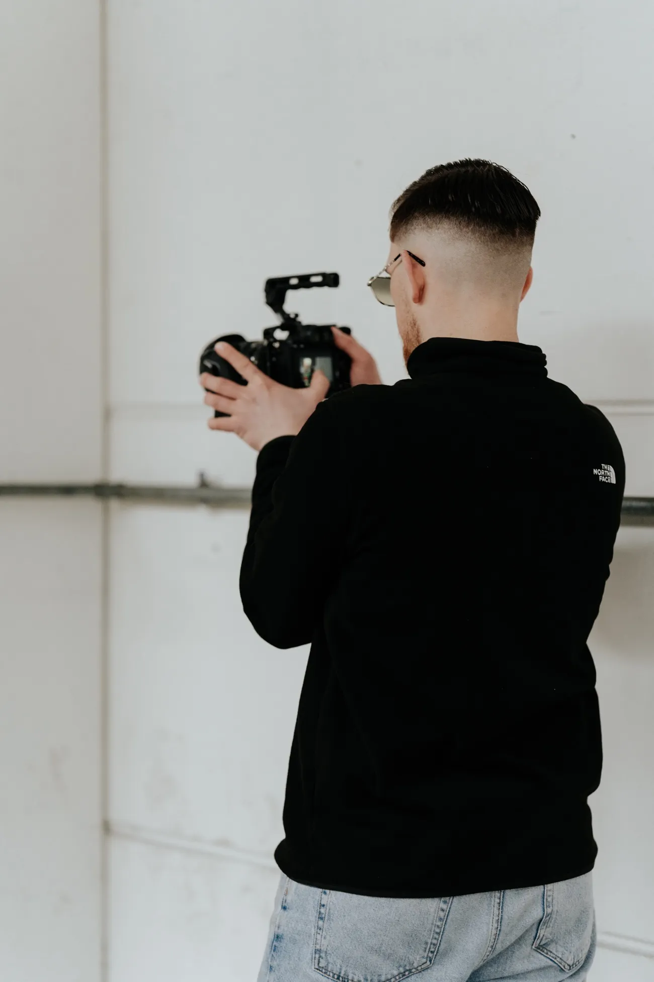 David Schulz filmt von hinten aufgenommen mit der Kamera an der Schulter.